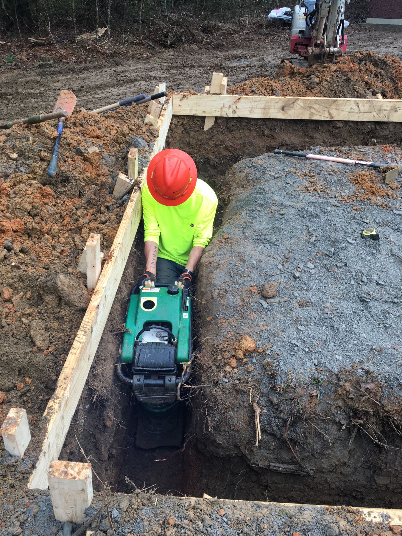 Tesa worker compacting a footing